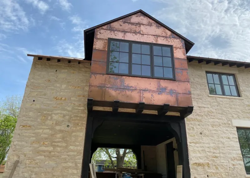 Copper metal panel facade on a stone building for Skylight Installation in Alliance