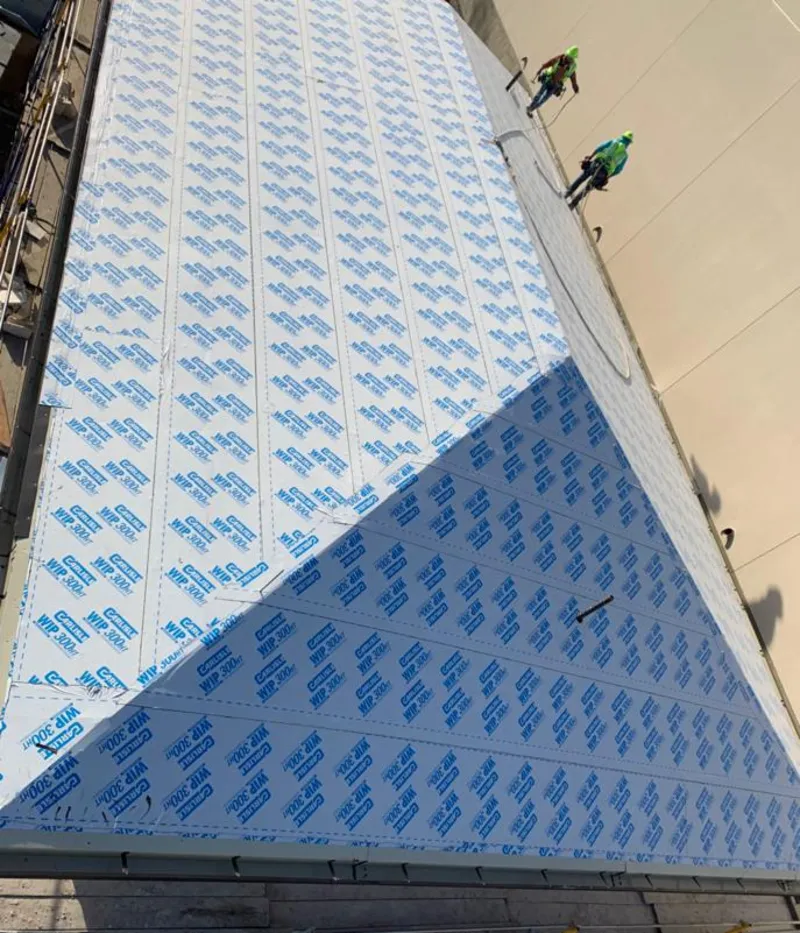 Professional roofers installing underlayment on a metal roof in Alliance